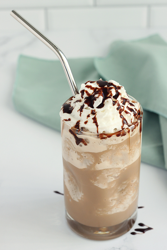 Iced coffee cocktail or frappe with ice cubes and cream in