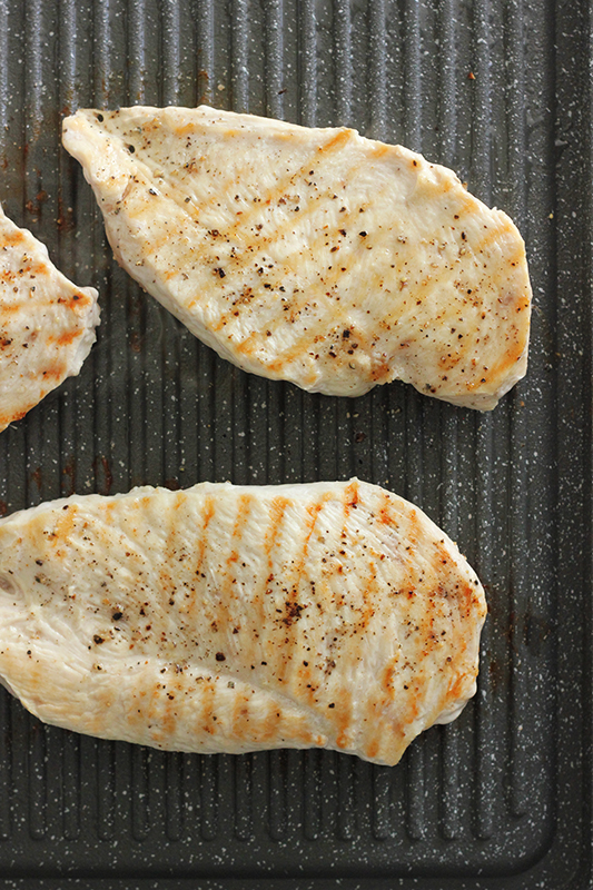 Chicken being grilled on a pan