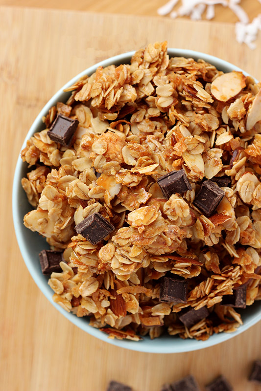 close up of granola in a light blue bowl with chocolate chunks