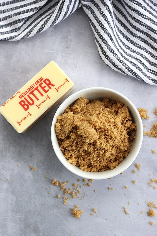 brown sugar in a bowl with a stick of butter on the side