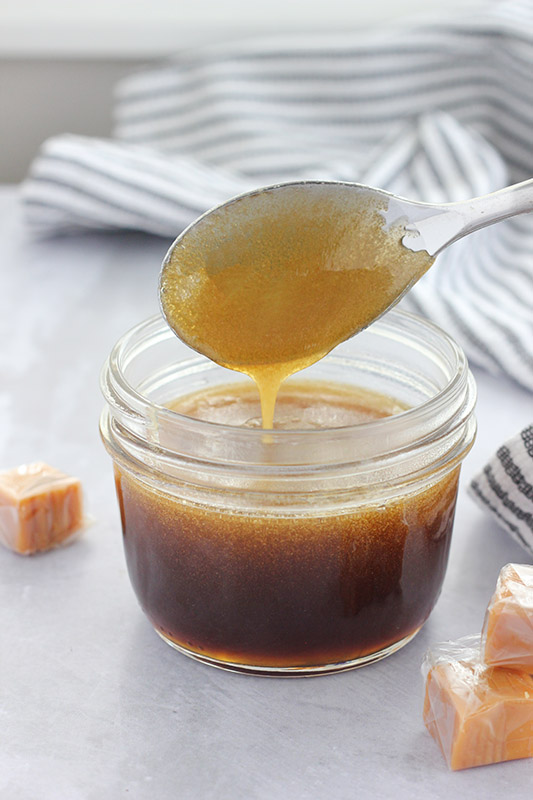 spoon of syrup drizzling down into a jar