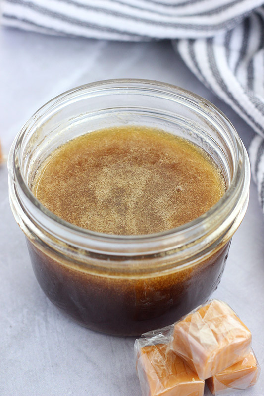 small mason jar of syrup on a tabletop 