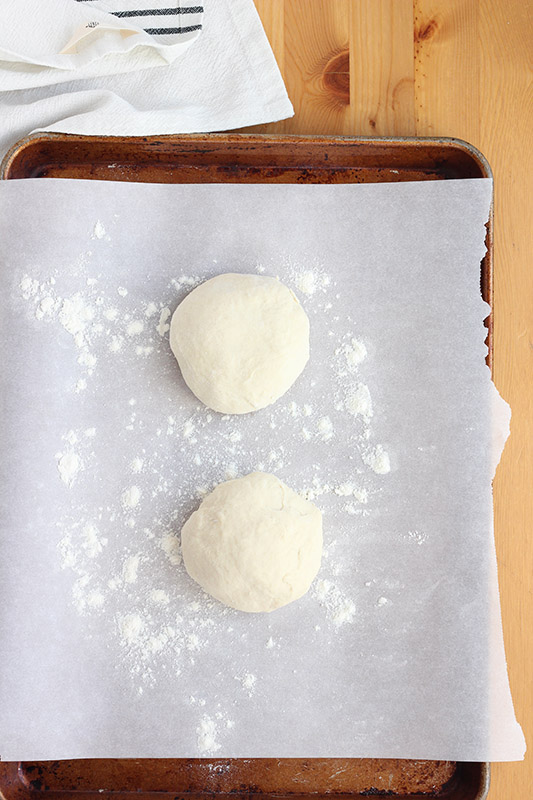 two dough balls on a parchment lined tray