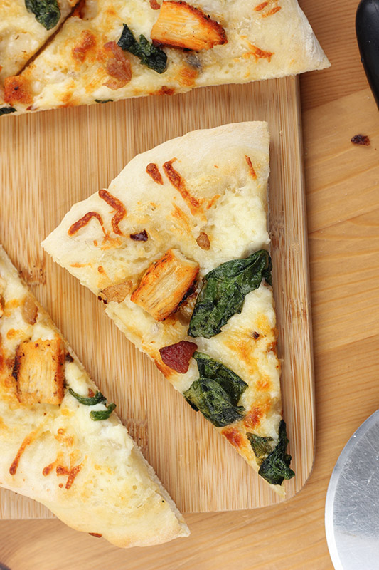 slice of chicken pizza on a cutting board