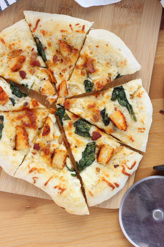 pizza on cutting board sliced into 8 pieces