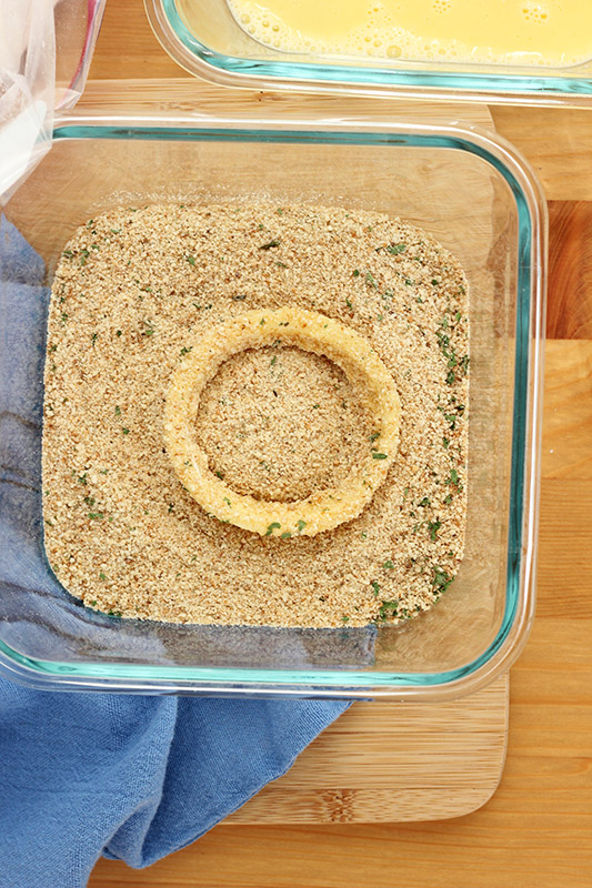 onion circle coated in breadcrumbs in a bowl