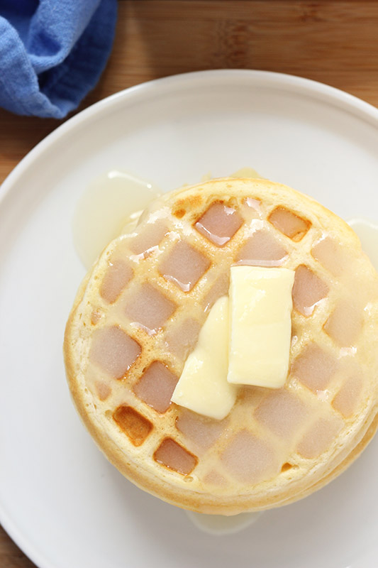 waffles on a white plate with butter and syrup