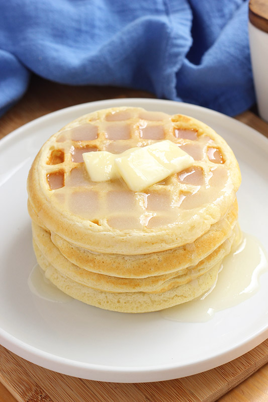 stack of waffles covered in syrup and butter