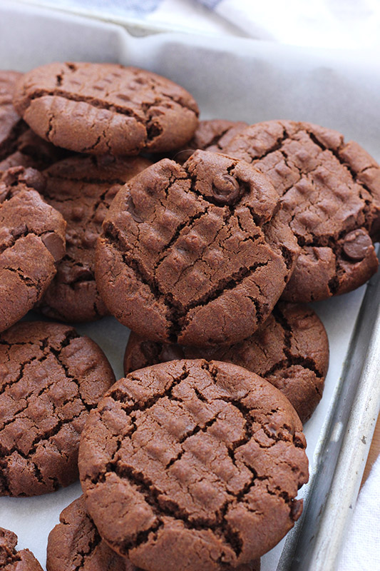 stack of chocolate cookies on white parchment