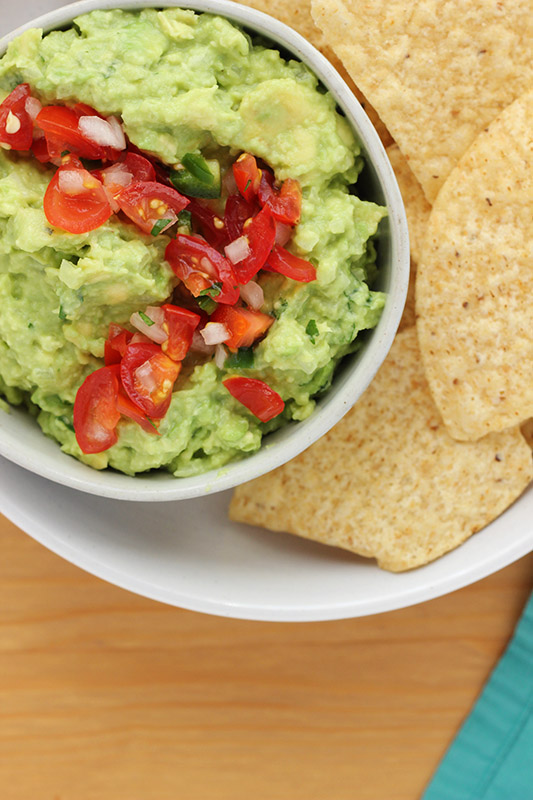 bowl of fresh guacamole with pico on top