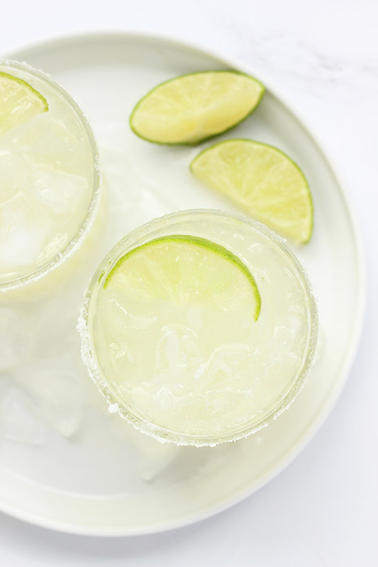 top down shot of a margarita in a glass with a lime