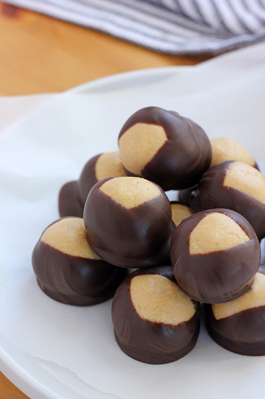 stack of chocolate peanut butter balls on a white plate