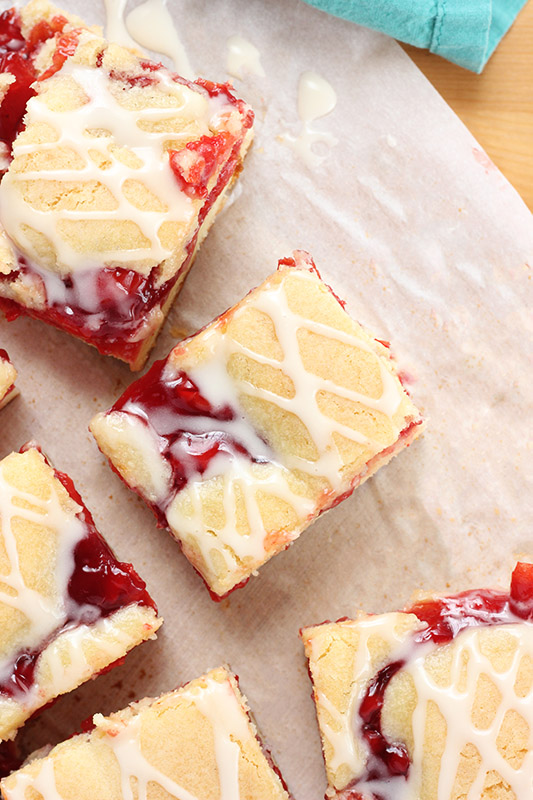 cherry pie bars with frosting drizzled on top