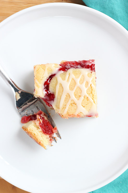 white plate with a single cherry bar with a bite on a fork