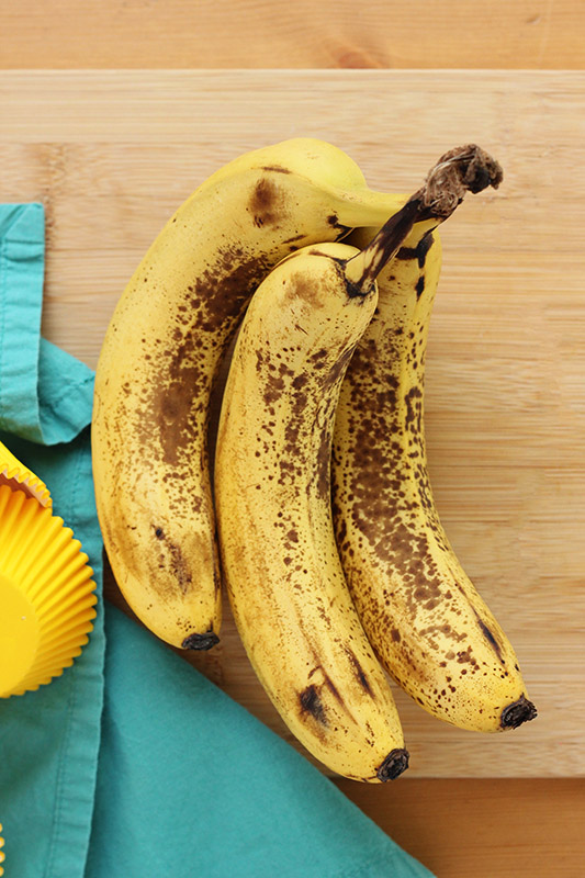 ripe bananas sitting on a wooden table