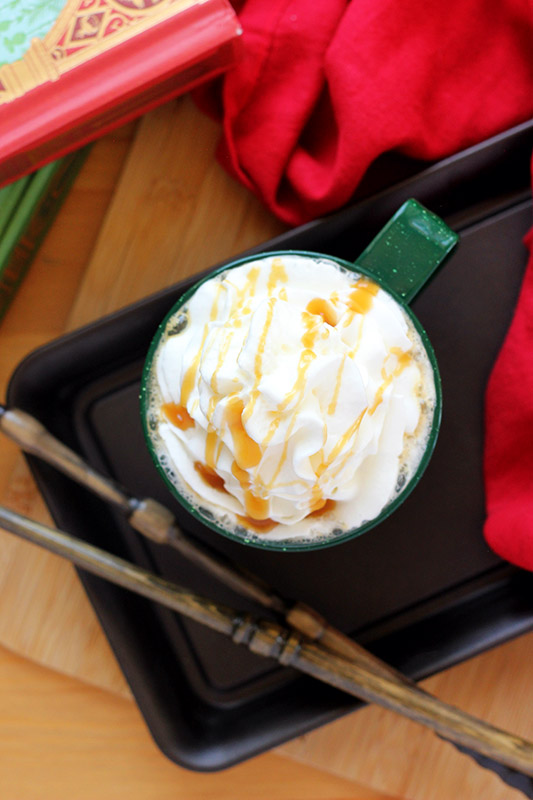 butterbeer latte in a green glass with whipped cream