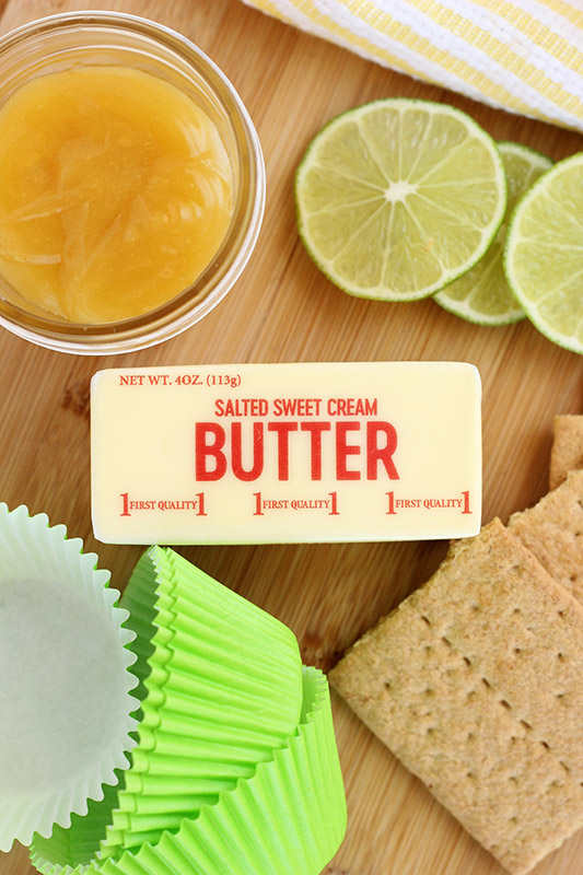 butter and lime curd on a cutting board with sliced limes and graham crackers