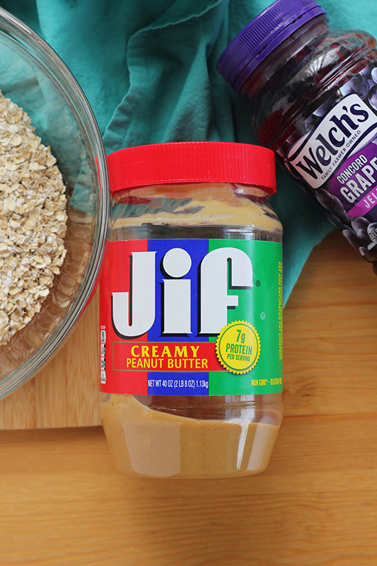 peanut butter jar that is half empty on a wooden table