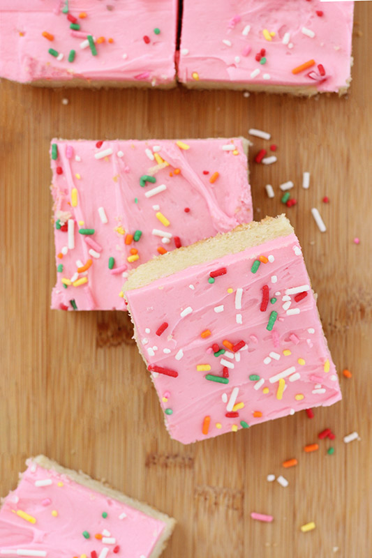 two sugar cookie bars stacked on a cutting board