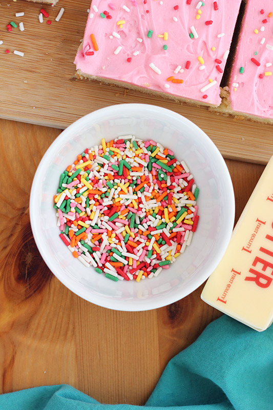 bowl of sprinkles and bar of butter on a wooden table top