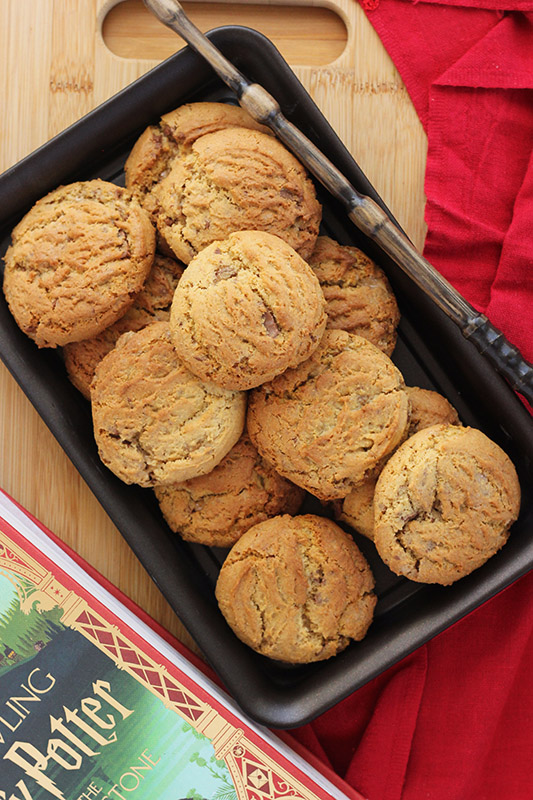 stack of cookies sitting on a black serving tray with a wand sitting on the edge of the plate