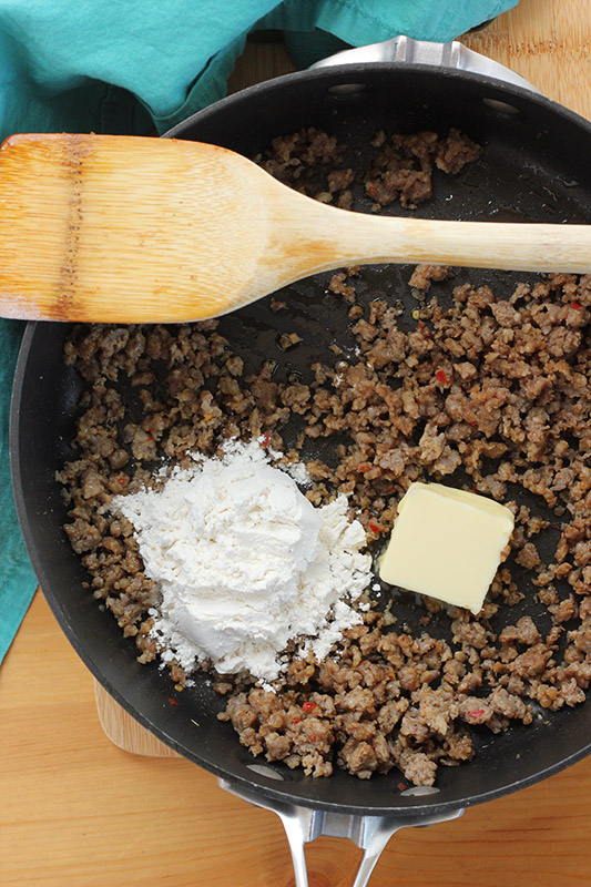 browned sausage in a pan with butter and flour