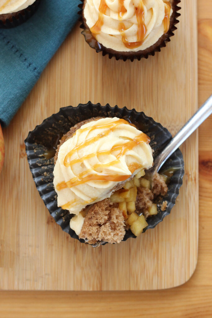 cupcake topped with caramel frosting with a bite sitting on a fork
