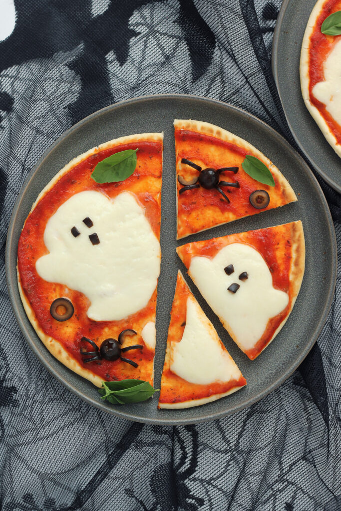 halloween ghost pizza with half cut into triangles