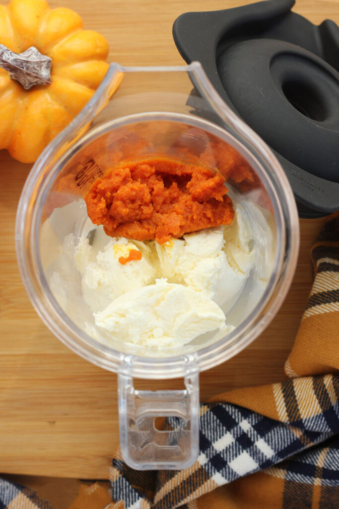 blender filled with ice cream and pureed pumpkin