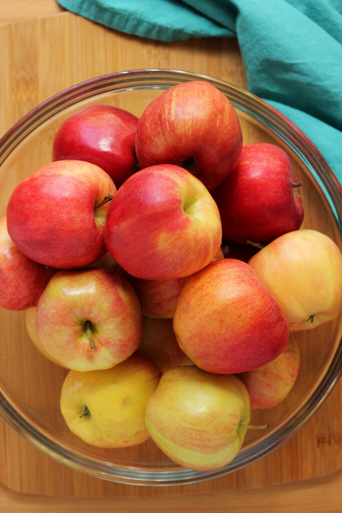 glass bowl filled with red and yellow apples
