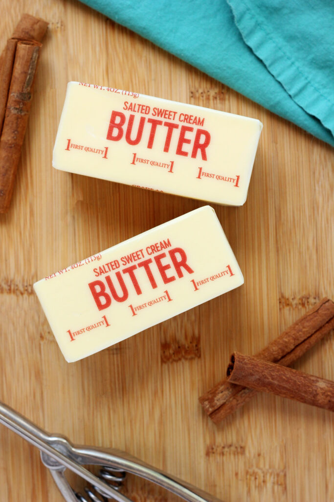butter and cinnamon sticks on a wooden cutting board