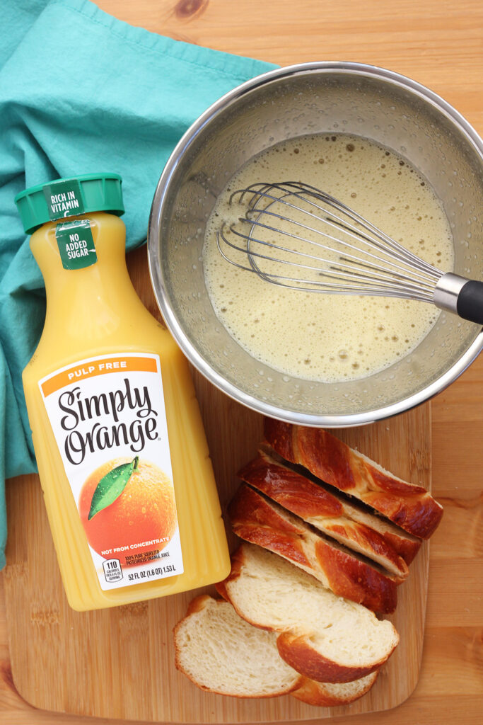 sliced challah bread, orange juice, and whipped eggs inside a bowl 