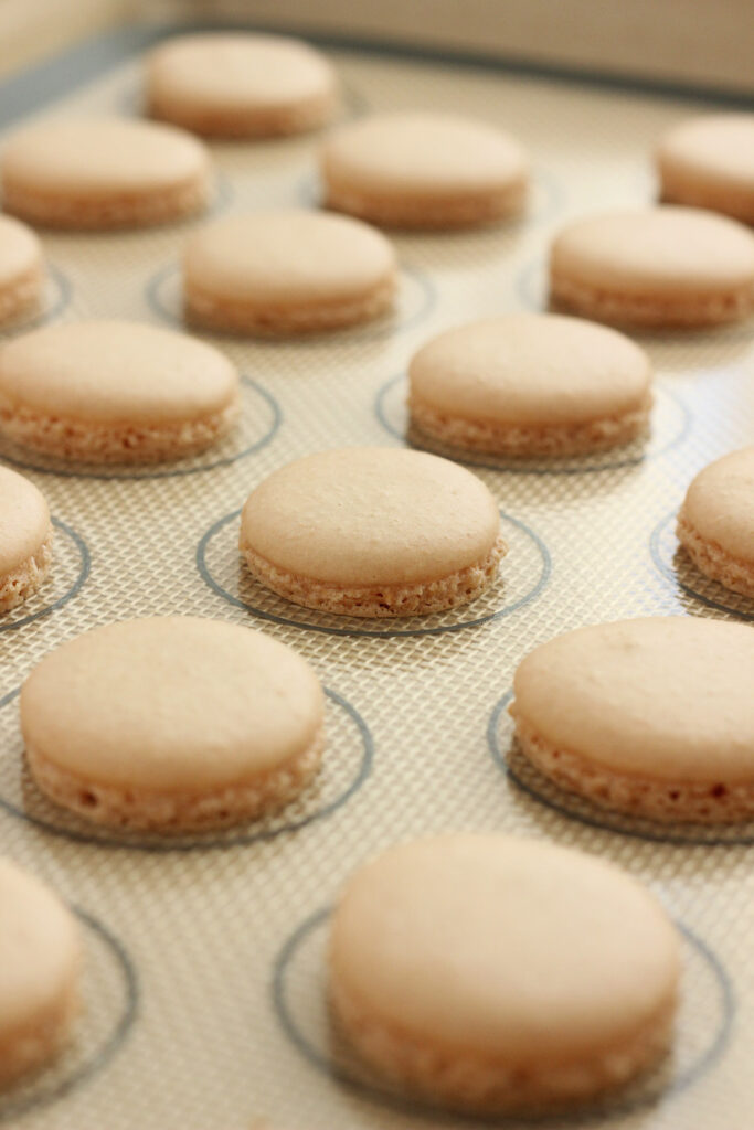 silicone baking mat filled with baked macarons