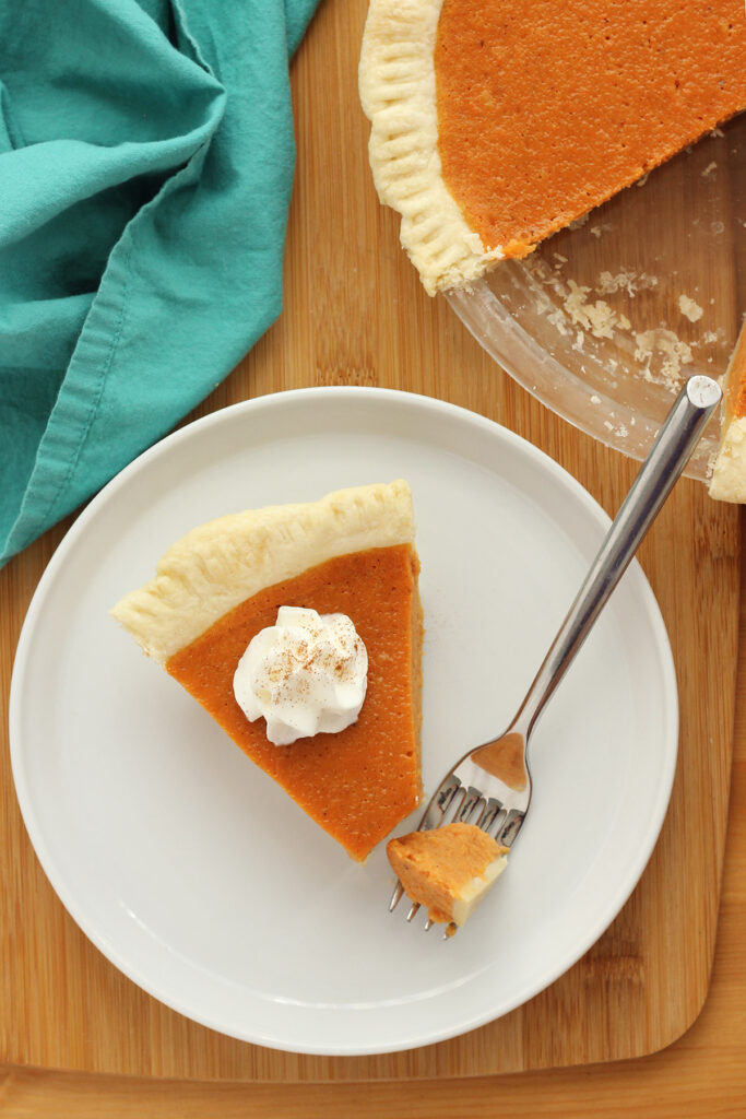 slice of pie with a bite sitting on a fork on a white plate