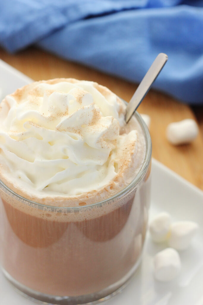 close up image of whipped cream topping that is sitting on cocoa 