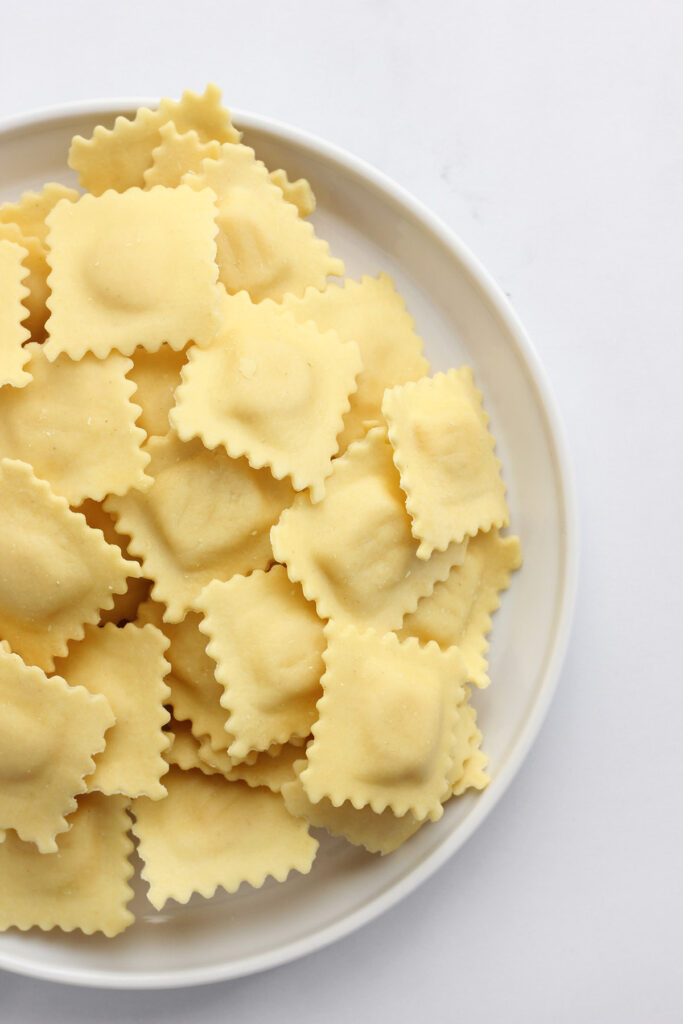 white plate filled with uncooked ravioli