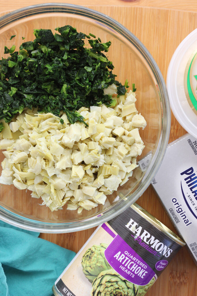 glass bowl with ingredients for artichoke dip