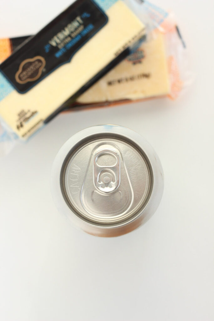 image of a beer can with two blocks of white cheddar