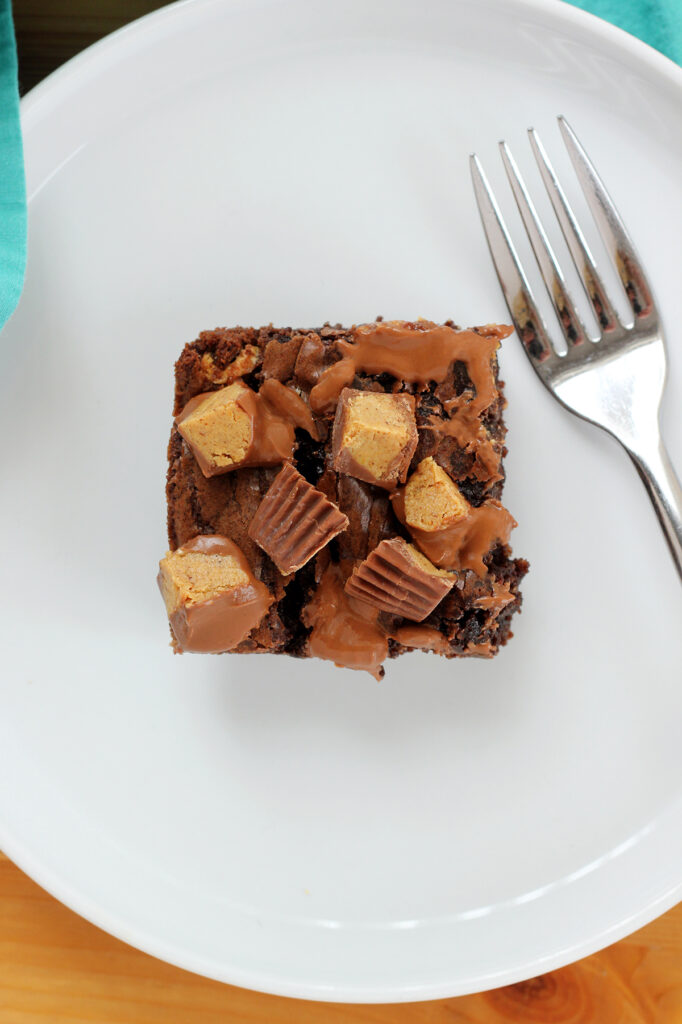 single brownie square on a with round plate with a fork off to the side