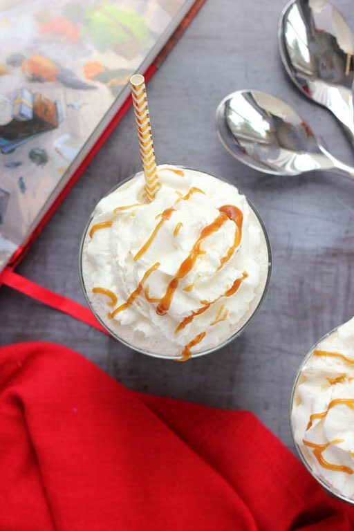 whipped cream in cup drizzled with butterscotch sauce