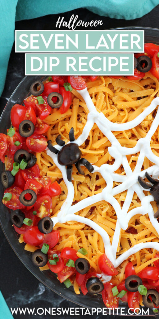  image showing a close up of half of a dish of dip topped with a sour cream spider web and spiders made out of olives sitting on a black table top with a teal napkin. Text overlay reads "halloween seven layer dip recipe"