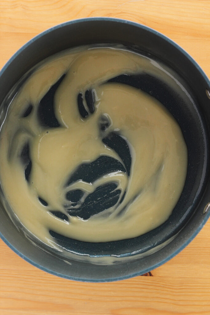 top down image showing a large pot filled with melted butter and flour that has been whisked together
