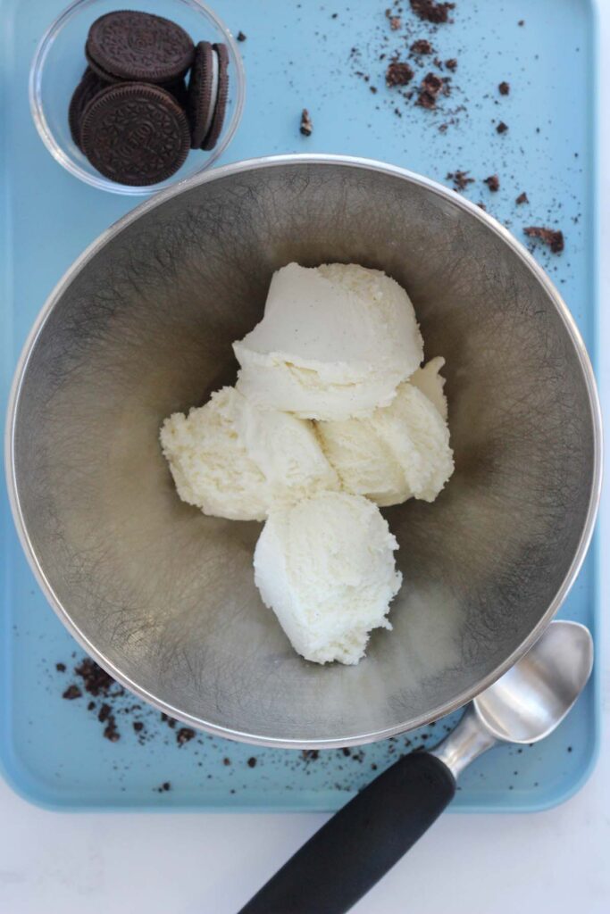 top down image showing a metal mixing bowl with vanilla ice cream scoops