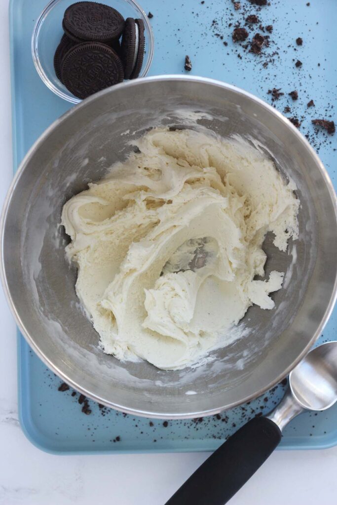 top down image showing a metal mixing bowl with vanilla ice cream that has been mixed