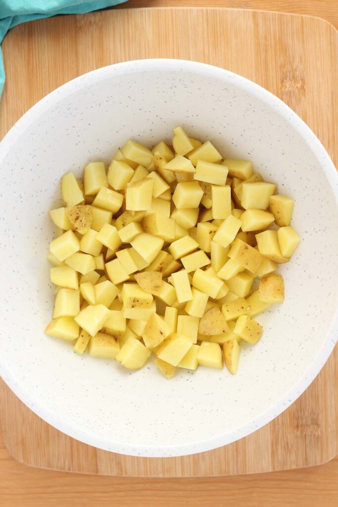 top down image showing a white mixing bowl filled with dried potato pieces