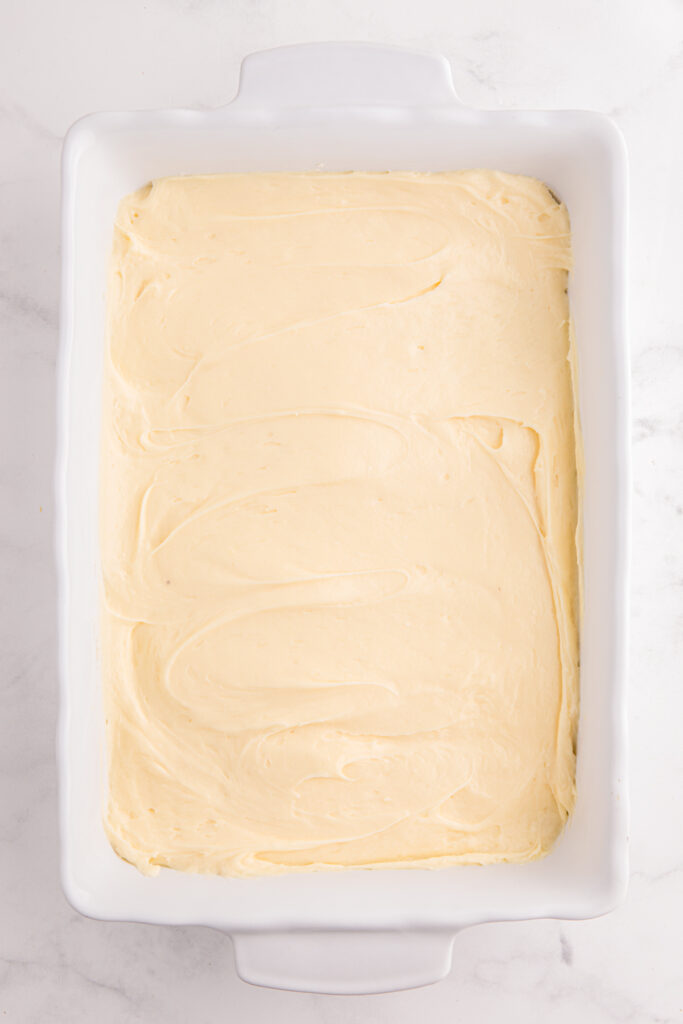 top down image showing a white rectangle baking dish filled with a cream cheese mixture. 