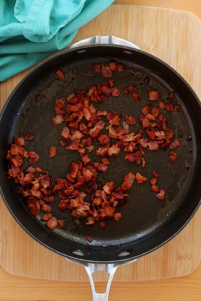 top down image showing a black skillet filled with cooked bacon pieces