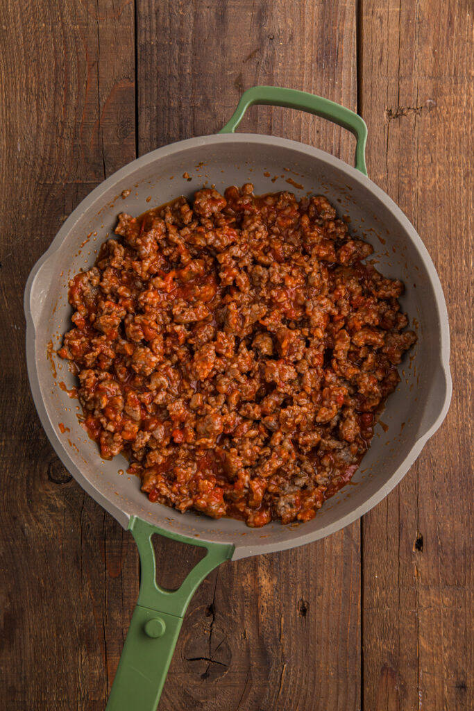 top down image showing a skillet with cooked ground beef with red sauce mixed in