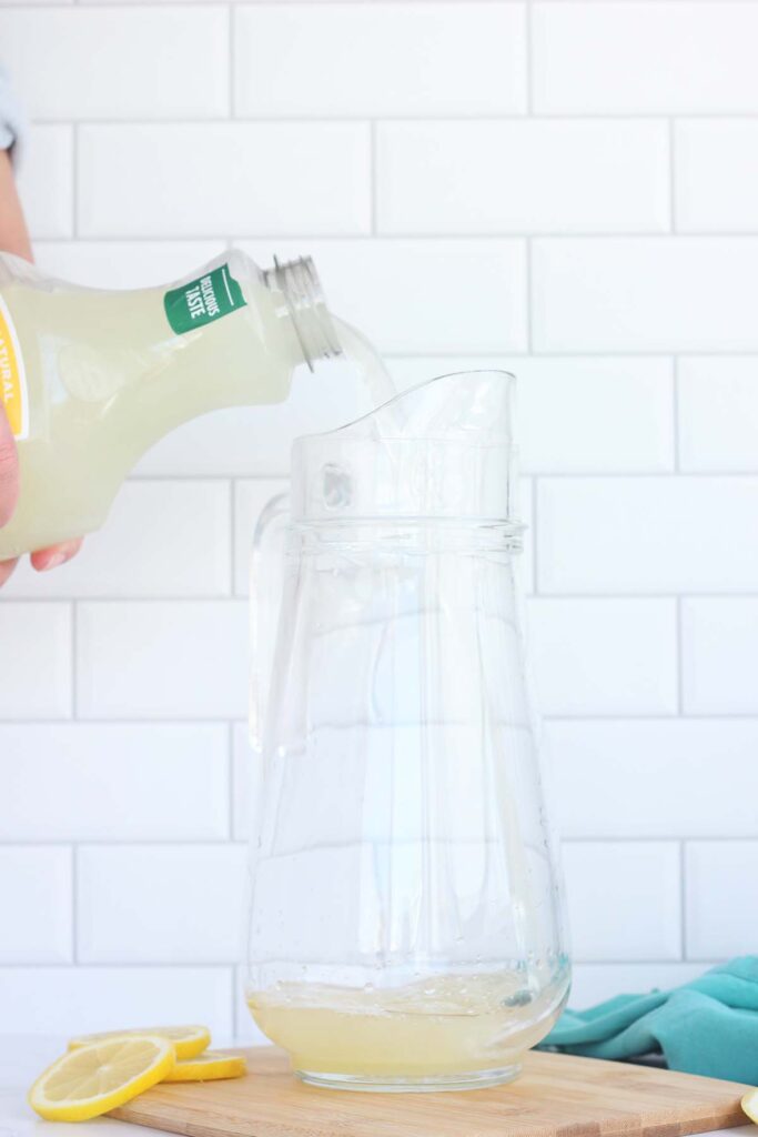 Lemonade being poured into a glass pitcher