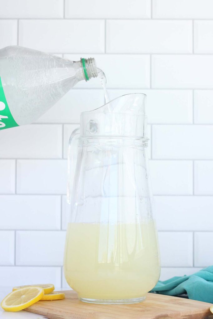 sprite being poured into a glass pitcher